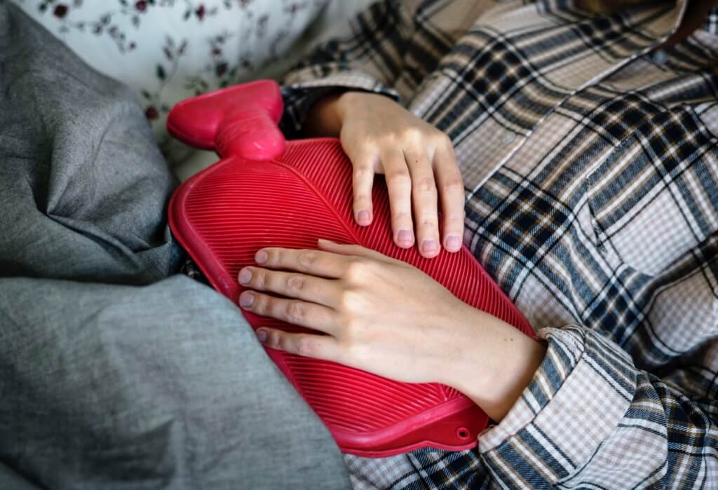 Women holding a hot water bottle on tummy