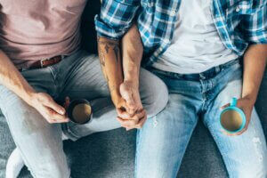 Gay couple holding hands with coffee