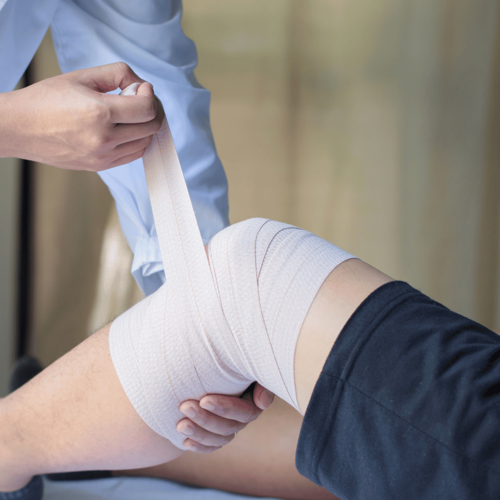 Doctor Applying Elastic Bandage to a Patient's Knee