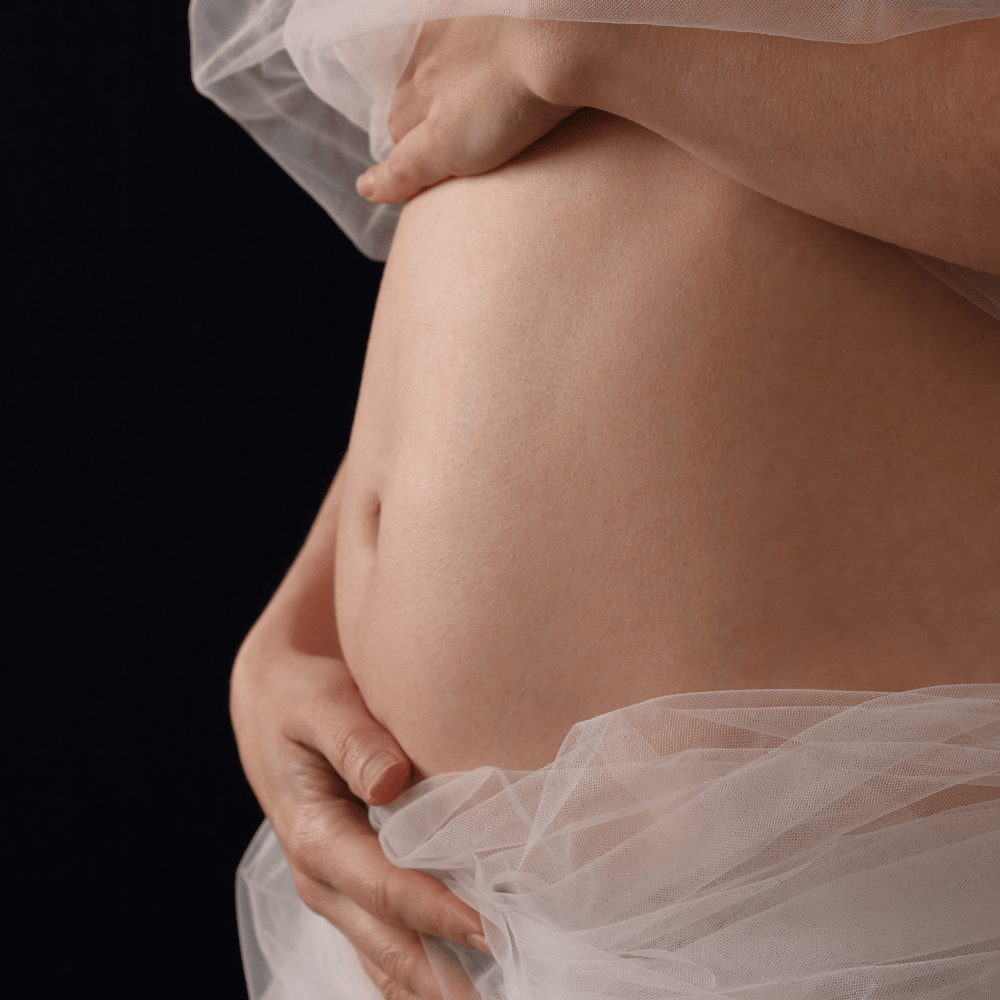 Pregnant Woman holding hands on her belly after pregnancy testing
