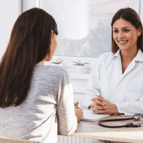 Beautiful female doctor consulting patient for early pregnancy