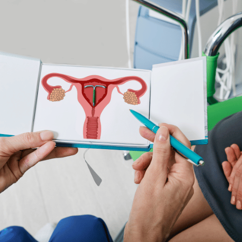gynaecologist showing female patient intrauterine contraceptive device or coil to prevent pregnancy while consultation