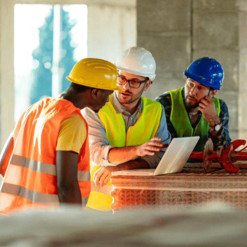 Construction workers using laptop on construction site
