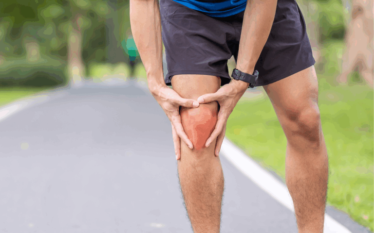 Man participating in a marathon experiencing knee pain while running