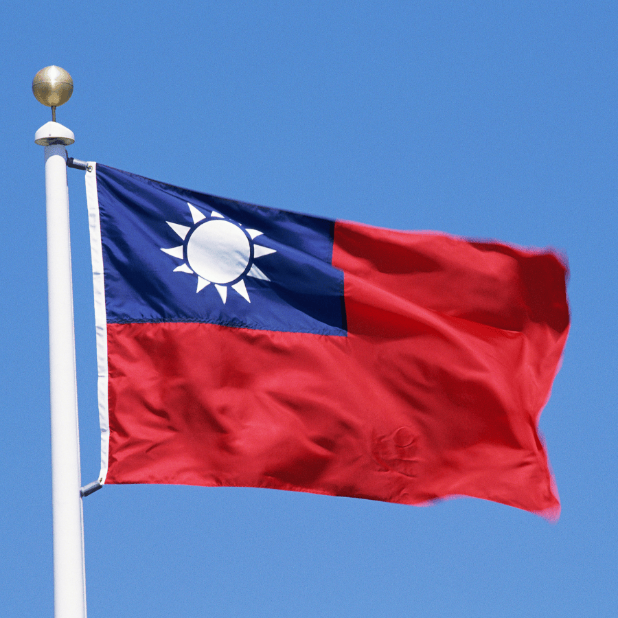 Taiwan national flag waving against a clear blue sky.