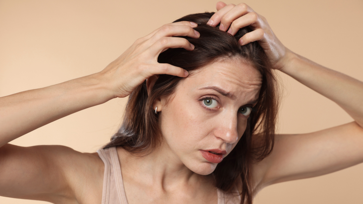 Worried brunette with hands in messy hair