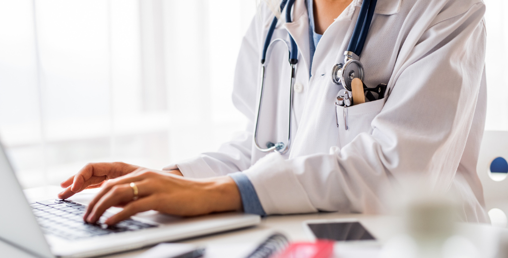 A doctor typing on a laptop, representing a same-day GP consultation.